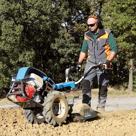 Bertolini 413 two-wheel walk-behind tractor with tiller box attachment preparing ground for plating or seeding  for a garden, vineyards or orchards.