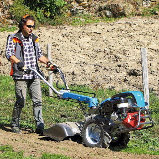 Bertolini 417 two-wheel walk-behind tractor with tiller box attachment preparing planting bed on a slight slope for a garden, vineyards or orchards.